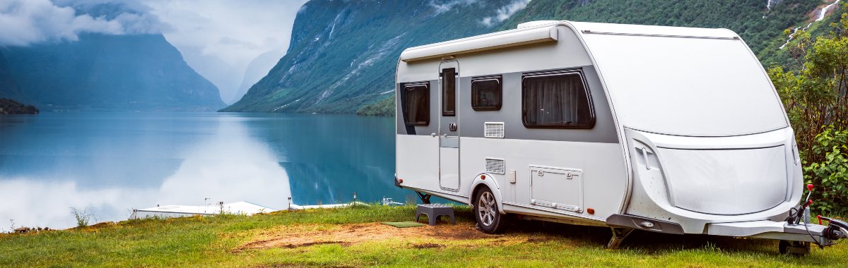 Caravan parked up in front of a lake