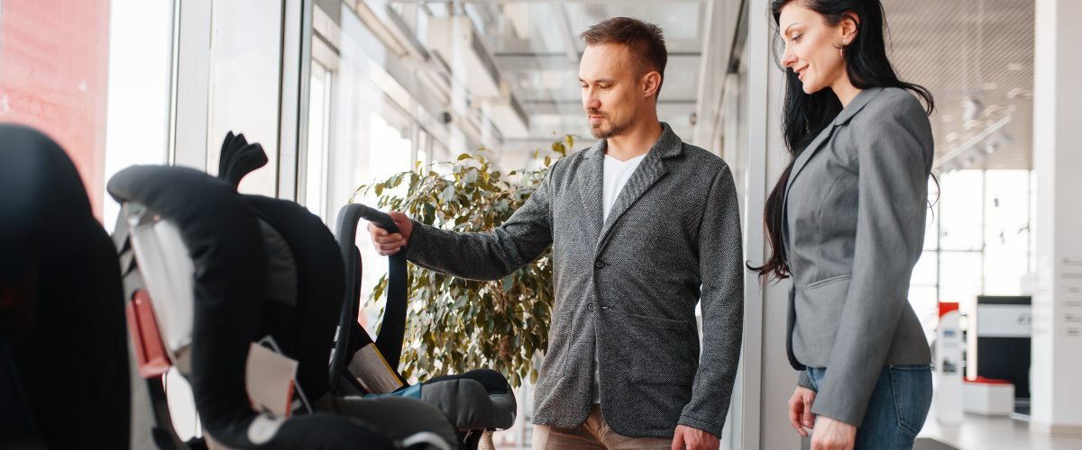 Man and woman choosing a child car seat