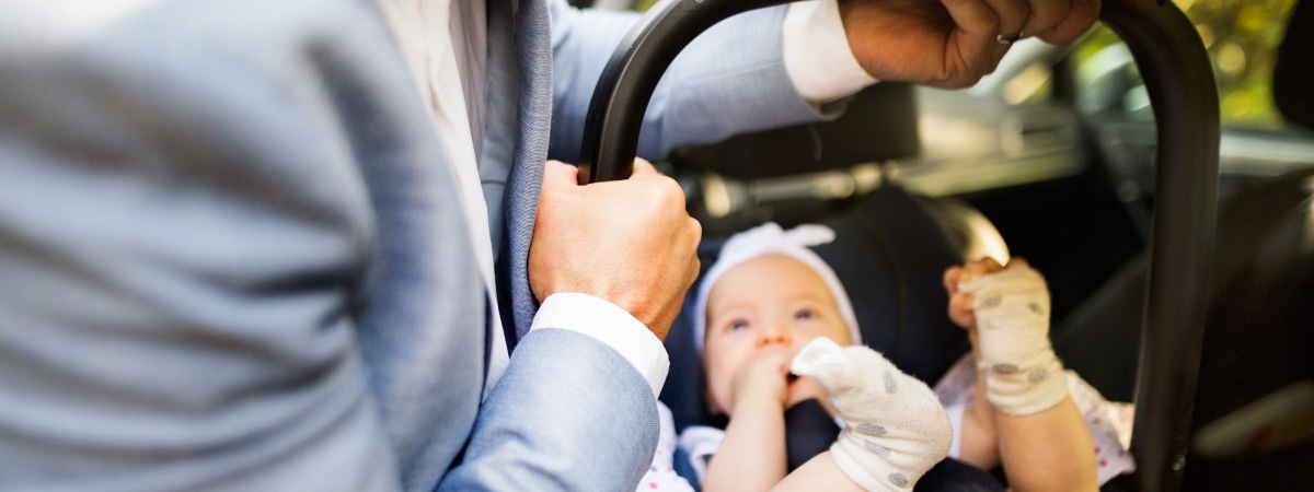 Man fitting car seat into a car