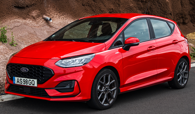 Red Ford Fiesta pictured on a road in front of mountains- Iconic Cars blog
