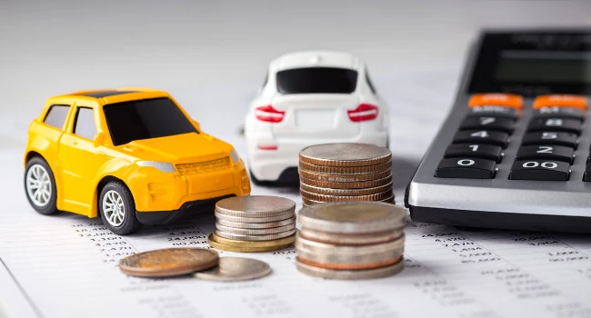 Toy cars alongside money and a calculator
